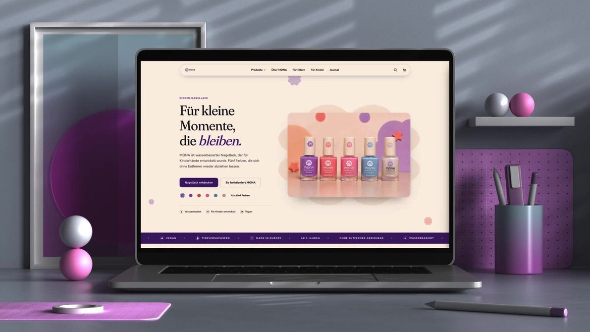 MONA: der Onlineshop auf einem Laptop vor einer flieder- und magentafarbenen Studiokulisse
